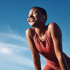 Fitness, black woman and smile in relax for running, exercise or workout in the nature outdoors. Happy African American female runner smiling on a break from run, exercising and breathing fresh air.